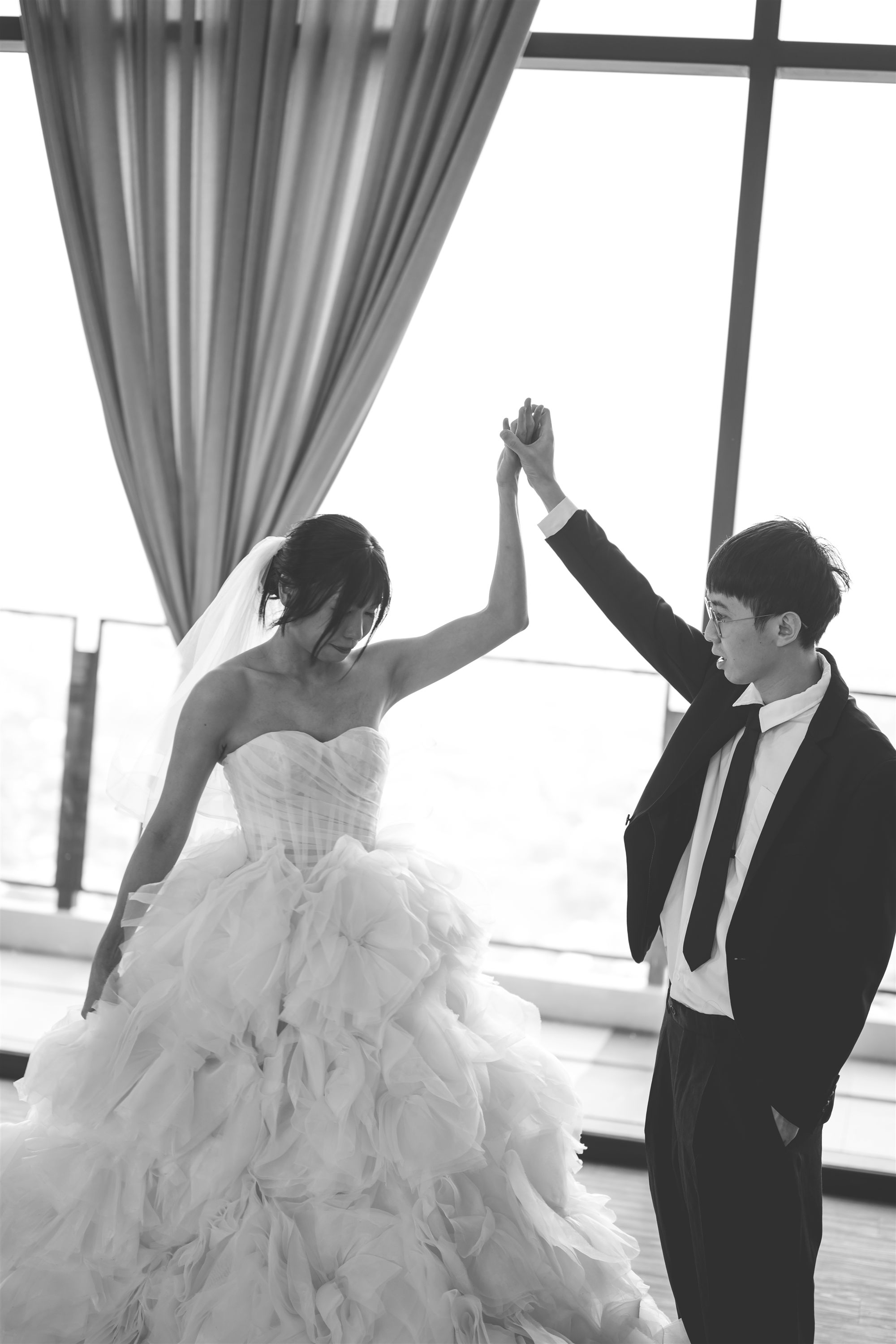 Couple dancing in front of panoramic window at W. in the Sky